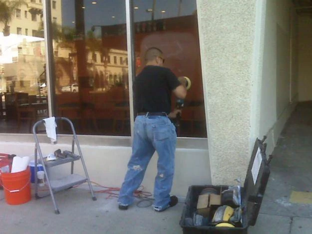 GlassRenu technician restoring installed storefront glass